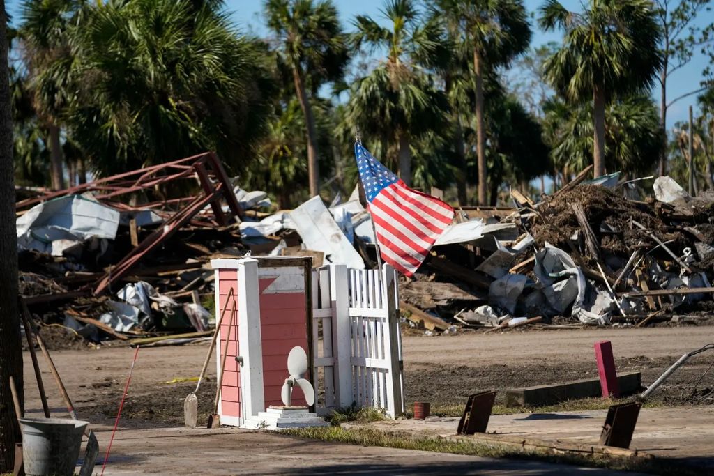 An American flag flies amid destruction in the aftermath of Hurricane Helene, in Jena, Florida