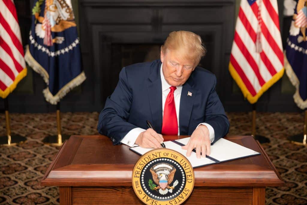 President Donald J. Trump signs an EO on Iran Sanctions in the Green Room at Trump National Golf Club Sunday, August 5, 2018, in Bedminster Township, New Jersey.